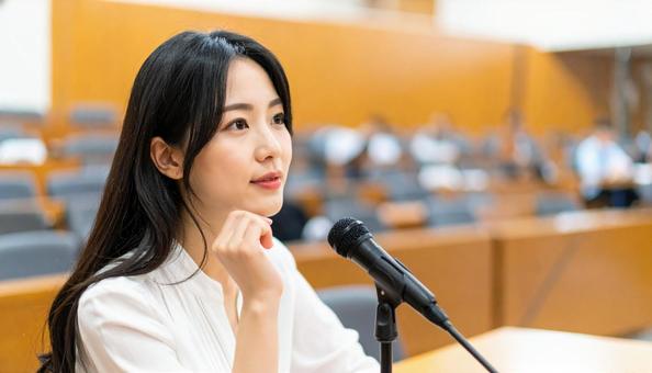 会議で発言する若い日本人女性の写真
