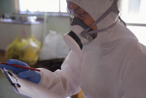 防護服で作業する特殊清掃員 防護服で作業する特殊清掃員の写真