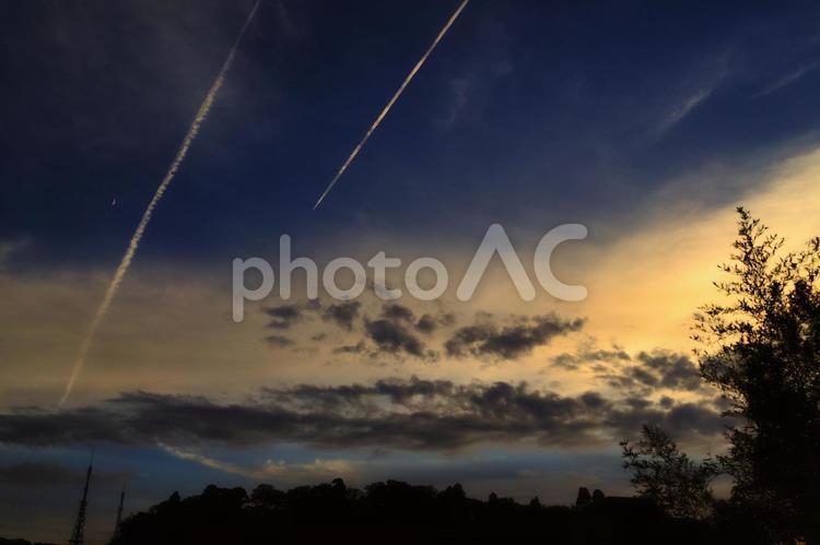 落ちる飛行機雲と夕日 飛行機雲,夕日,落ちるの写真素材