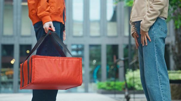 屋外でピザのデリバリーをする男性と取りに来た女性客 配達,フードデリバリー,デリバリーの写真素材