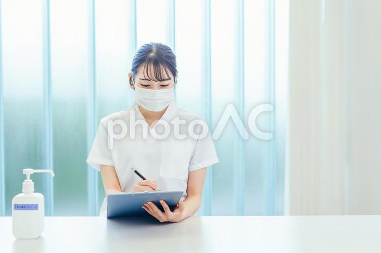 カウンセリングするマスクをする白衣姿の女性 医療事務,レセプト,レセプションの写真素材