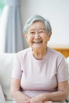 にっこり笑う半袖の高齢女性 女性,笑顔,ソファの写真素材