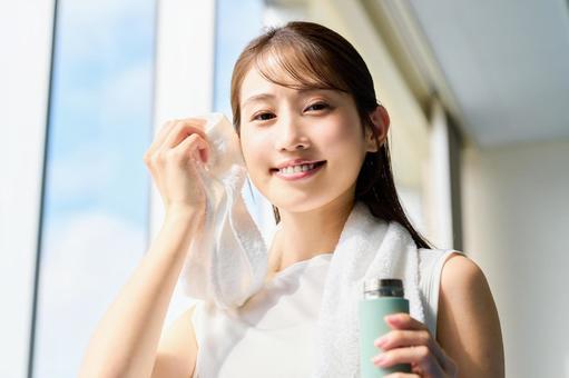 スポーツジムで汗を拭く女性 女性,トレーニング,汗を拭くの写真素材