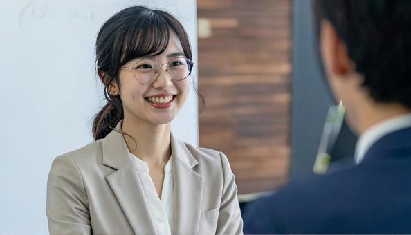 笑顔で話すスーツ姿の女性 笑顔で話すスーツ姿の女性の写真