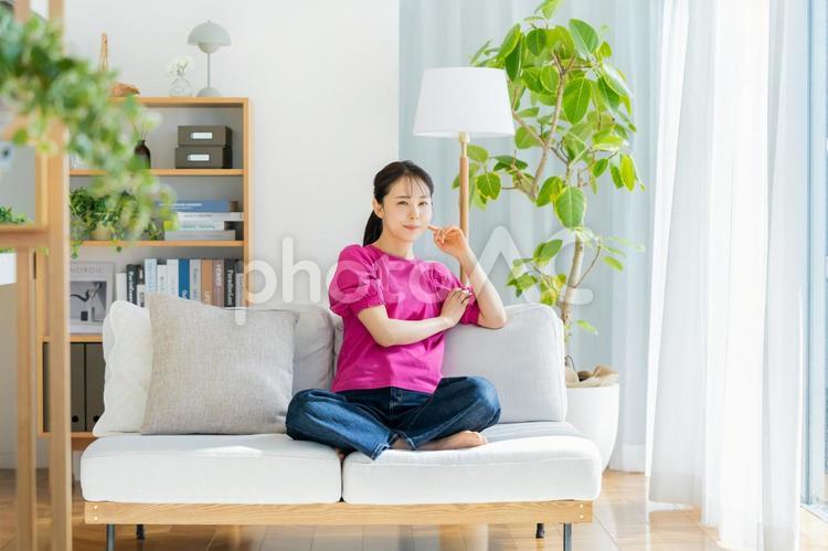 ソファでくつろぐ若い女性 若い女性,笑顔,ポートレートの写真素材