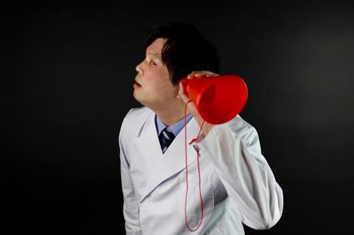 白衣の男性が赤い筒で聞く 男性,白衣,赤い筒の写真素材