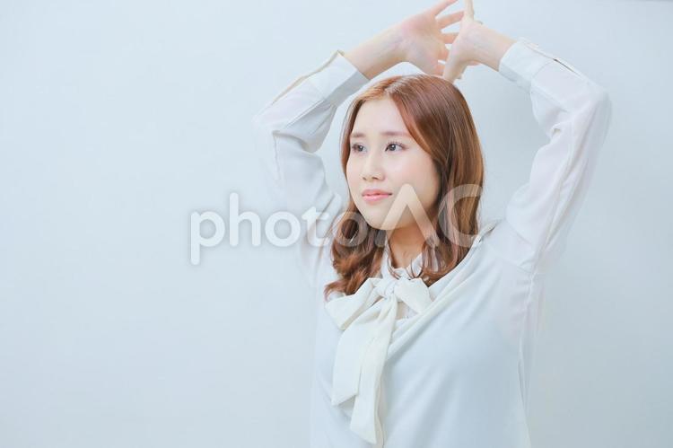 体操をする白いブラウス姿の若い女性 女性,ストレッチ,運動の写真素材