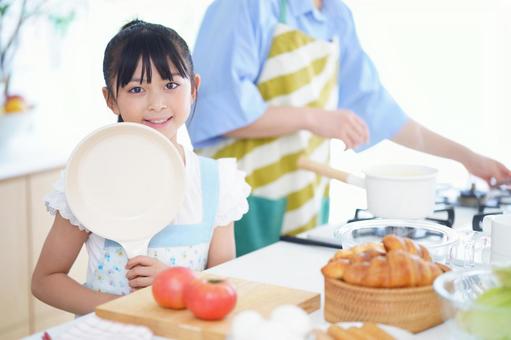 フライパンを手に笑顔を見せる女の子 女の子,フライパン,持つの写真素材