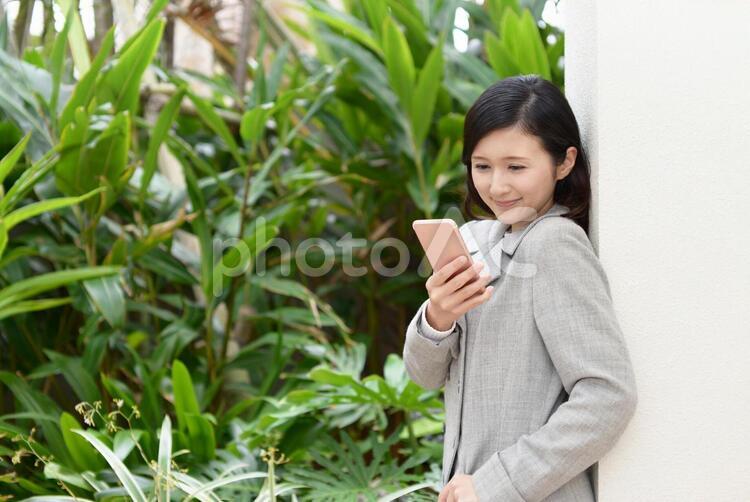 スマートフォンを持つ笑顔の女性 女性,スマートフォン,女の写真素材