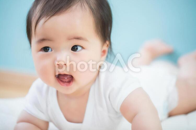うつ伏せになった笑顔の赤ちゃん 赤ちゃん,赤ん坊,あかんぼうの写真素材