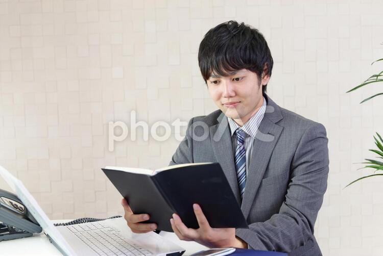 スケジュールを確認する男性 男性,男,ノートの写真素材
