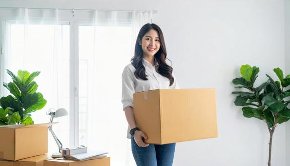微笑みながら引越し作業をする女性 微笑みながら引越し作業をする女性の写真