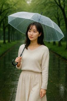 雨の日公園を歩く女性 雨の日公園を歩く女性の写真