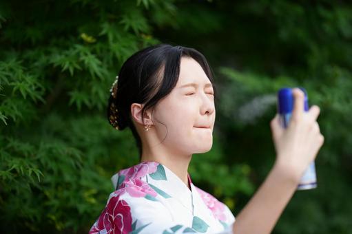 浴衣姿の女性が公園でスプレーを使う 女性,浴衣,スプレーの写真素材