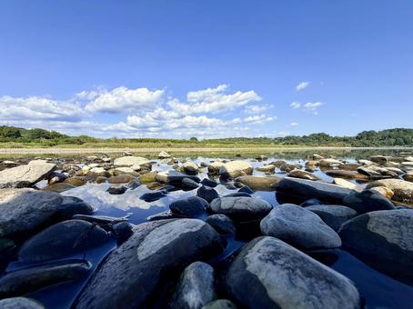 青空と石ころの牧歌的な川辺の風景 青空と石ころの牧歌的な川辺の風景 青空,川辺,河原の写真素材