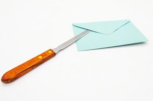 レターナイフで水色の封筒を開封するシーン レターナイフ,レターオープナー,ペーパーナイフの写真素材