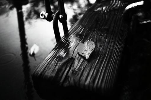 落ち葉のモノクロ写真 落ち葉,ベンチ,雨の写真素材