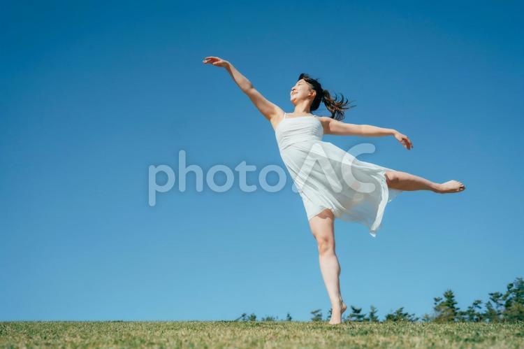 空と白いワンピースの踊る女性（アラベスク） 女性,空,美容の写真素材