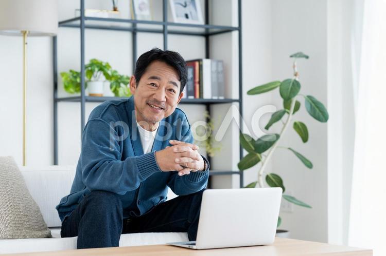 リビングでパソコンを使うミドルの男性 パソコン,ミドル,男性の写真素材
