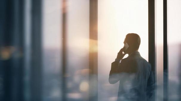 通話する男性の後ろ姿 通話する男性の後ろ姿の写真
