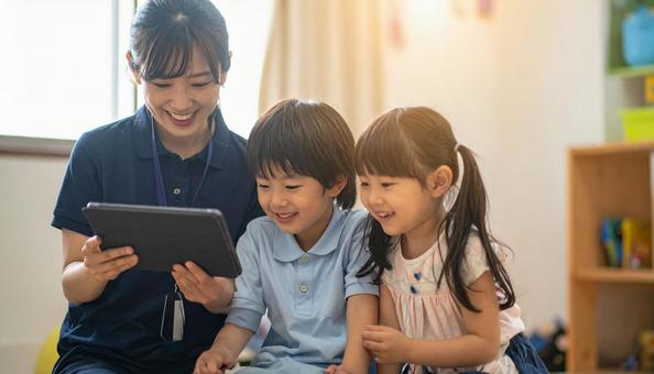 タブレットで遊ぶ保育士と子ども タブレットで遊ぶ保育士と子どもの写真