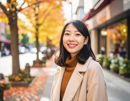 秋の街を歩く笑顔の女性 秋の街を歩く笑顔の女性の写真