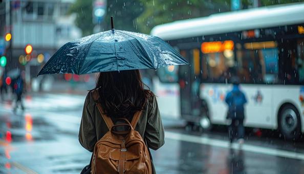 雨の中バス停でバスを待つ日本人女性 雨の中バス停でバスを待つ日本人女性の写真