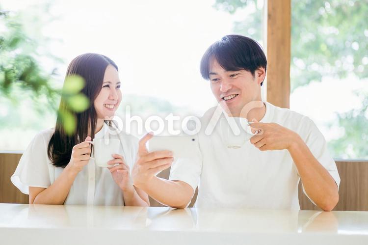 ダイニングでスマホを使う男女 スマホ,夫婦,スマートフォンの写真素材