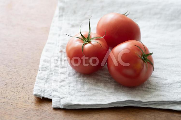 畳んだリネンに乗せたトマト3個　左空け トマト,とまと,野菜の写真素材