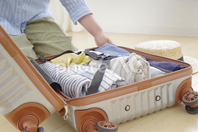 旅行の支度をするシニア女性の手元 トランク,スーツケース,荷造りの写真素材