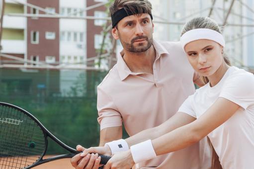 フォームを指導する男性と真剣な表情の女性 男女,外国人,テニスの写真素材