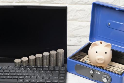 パソコンと貯金箱と手提げ金庫と一万円札 パソコンと貯金箱と手提げ金庫と一万円札の写真