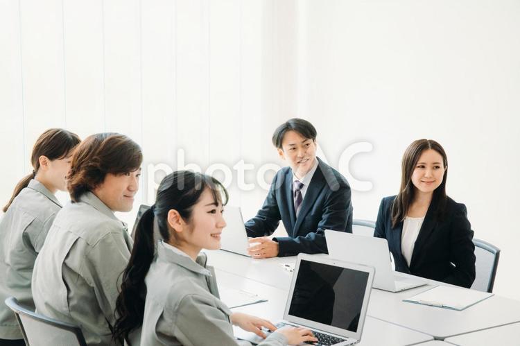 会議をするスーツと作業着姿の男女 オンライン会議,会議,会社の写真素材