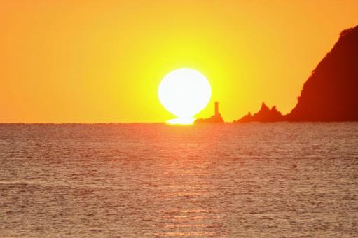 灯台横に沈むダルマ夕日 ダルマ夕日,夕日,灯台の写真素材