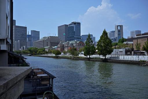都会のビルの前を雄大に流れる運河の写真