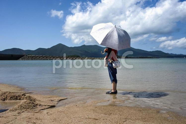 ＜素材＞真夏の浜辺を日傘で散策する女性 女性,海,空の写真素材