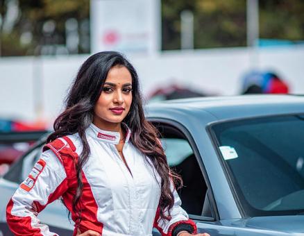 車の横に立つ女性レーサー 車の横に立つ女性レーサーの写真