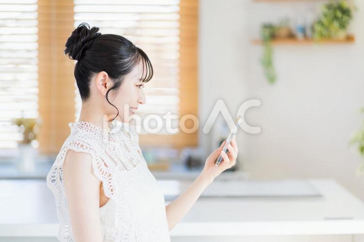 スマートフォンを操作する笑顔の若い女性。 スマートフォン,女性,1人の写真素材