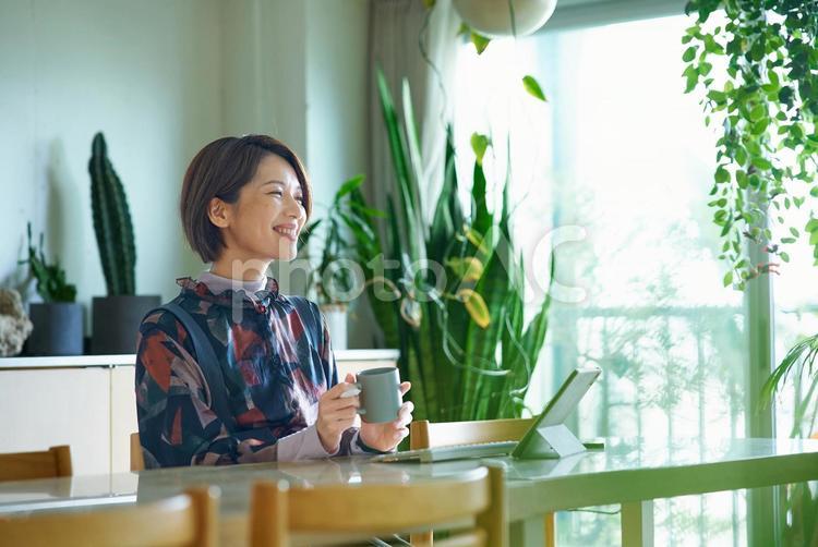 仕事中にマグカップを持って休憩する女性 在宅ワーク,コーヒー,リモートワークの写真素材