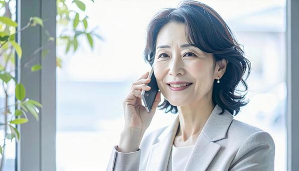 笑顔で電話する中年 笑顔で電話する中年の写真