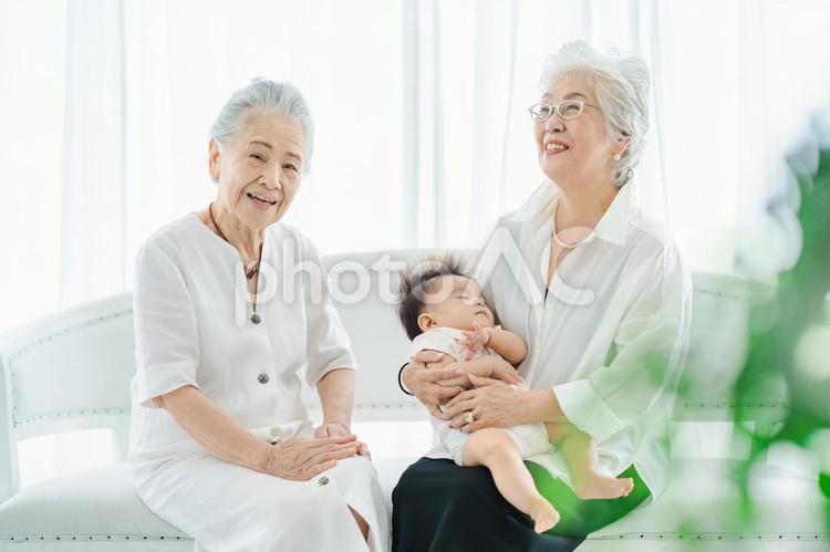 赤ちゃんを抱っこするシニア女性 孫,おばあちゃん,肌の写真素材