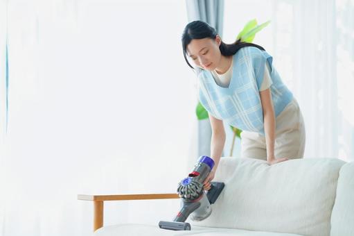 ソファを掃除する日本人女性 女性,掃除機,ソファの写真素材