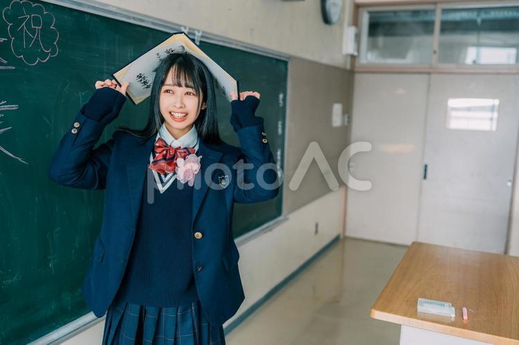 卒業証書を頭にのせてはしゃぐ女子高校生 女性,女子高,高校生の写真素材