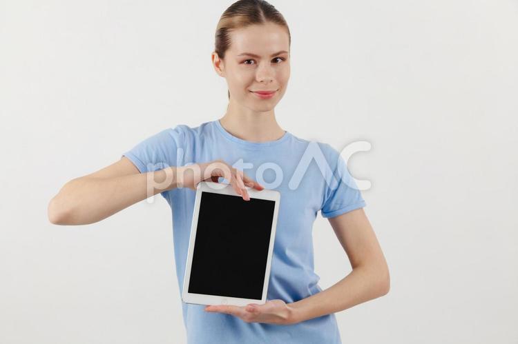 カメラ目線で微笑みタブレットを持つ女性 女性,タブレット,画面の写真素材