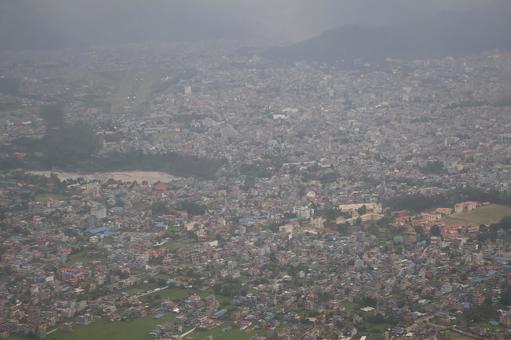 山からの霧で霞むネパールポカラの街並みの写真