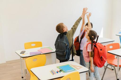 ハイタッチする生徒の後ろ姿 男の子,女の子,子どもの写真素材