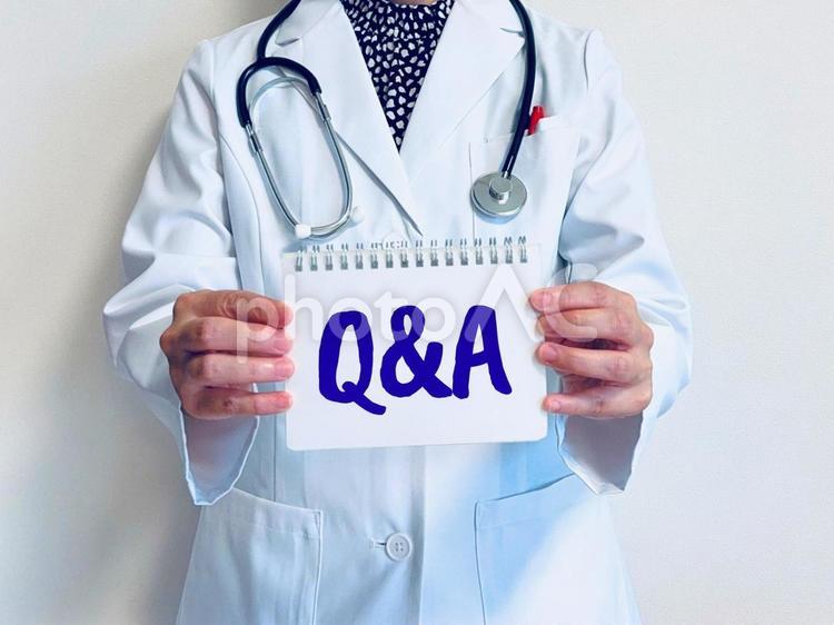 Q&Aと書かれたノートを持つ女医 q&a,クエスチョン,アンサーの写真素材