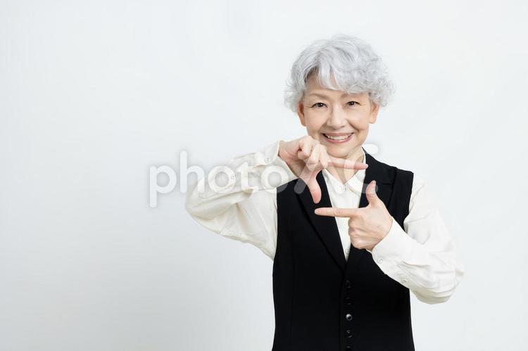 写真を撮るポーズをするシニア女性 女性,シニア,グレイヘアーの写真素材