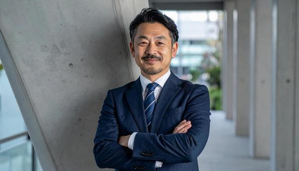 腕組みするスーツ姿の40代ビジネスマン 腕組みするスーツ姿の40代ビジネスマンの写真