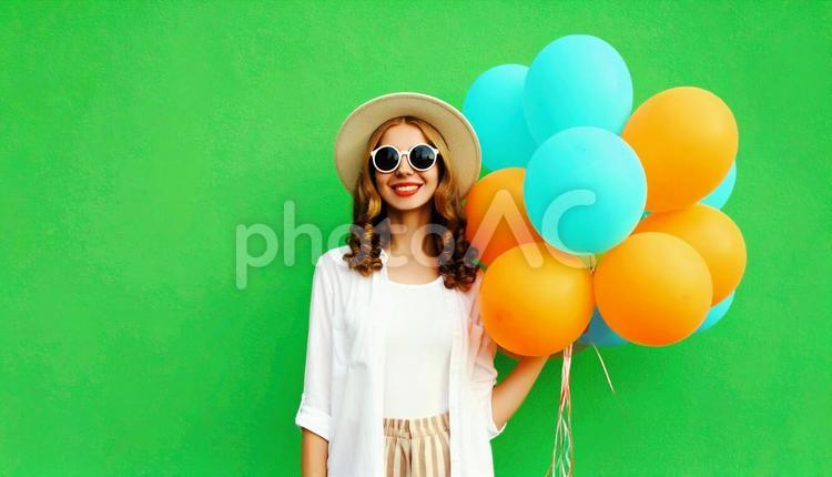 風船を持つおしゃれな女性 風船,グリーンバック,ファッションの写真素材